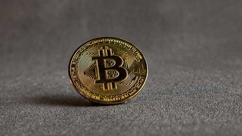 عکس سکه بیت کوین روی زمین خاکستری