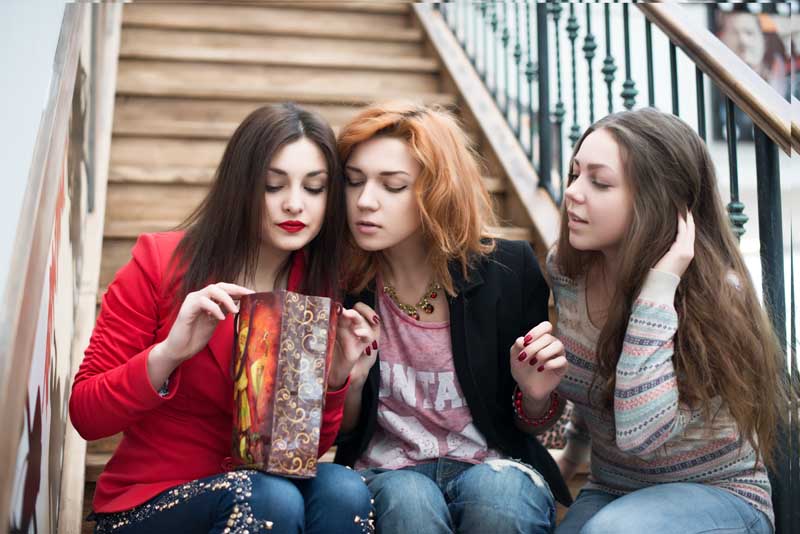 دانلود تصویر با کیفیت سه خانم در حال دیدن ساک دستی خرید