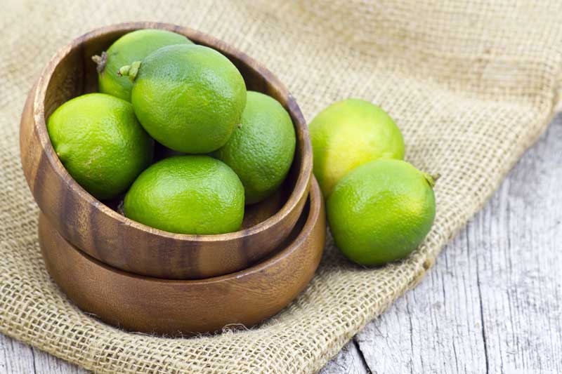 تصویر با کیفیت از لیمو ترش در کاسه چوبی