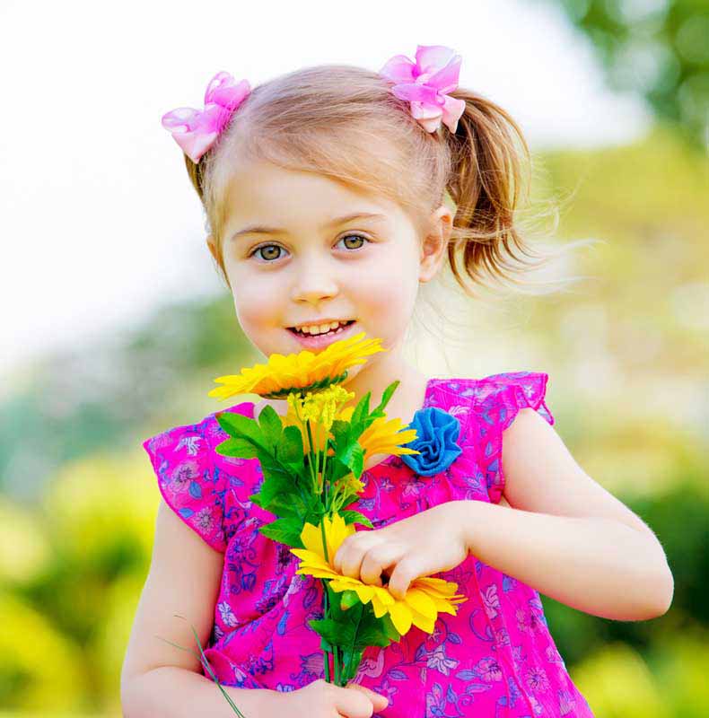 دانلود تصویر با کیفیت دختر بچه زیبا با چشمان بز و گل های زیبا