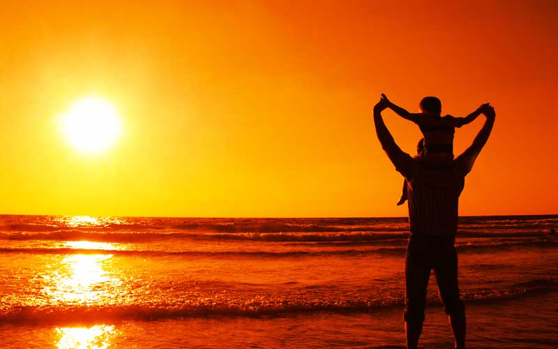 دانلود تصویر باکیفیت پدر و پسر کنار آب در غروب افتاب