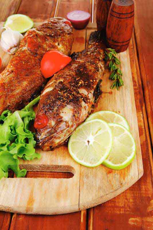 عکس با کیفیت از ماهی با لیمو روی تخته